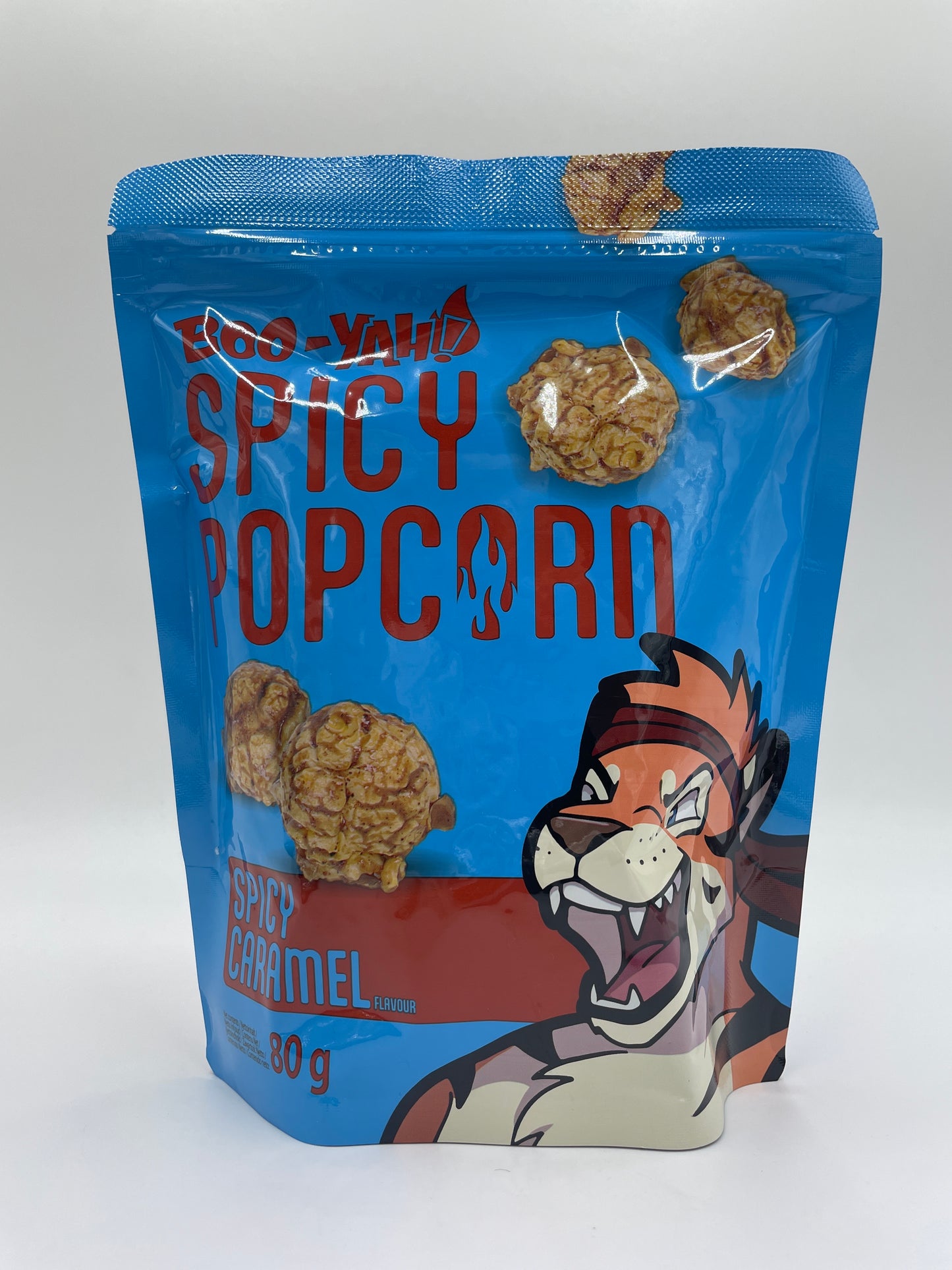 Krydret popcorn med karamel-smag fra BOO-YAH, sprød snack med gyldent popcorn og karamelfarvet overflade.