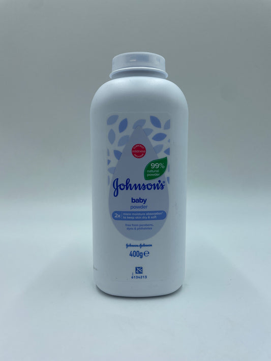 Børne pulver fra JOHNSON’S med børnevenlige ingredienser, vist i en åbnet pakke med pulver og en ske.